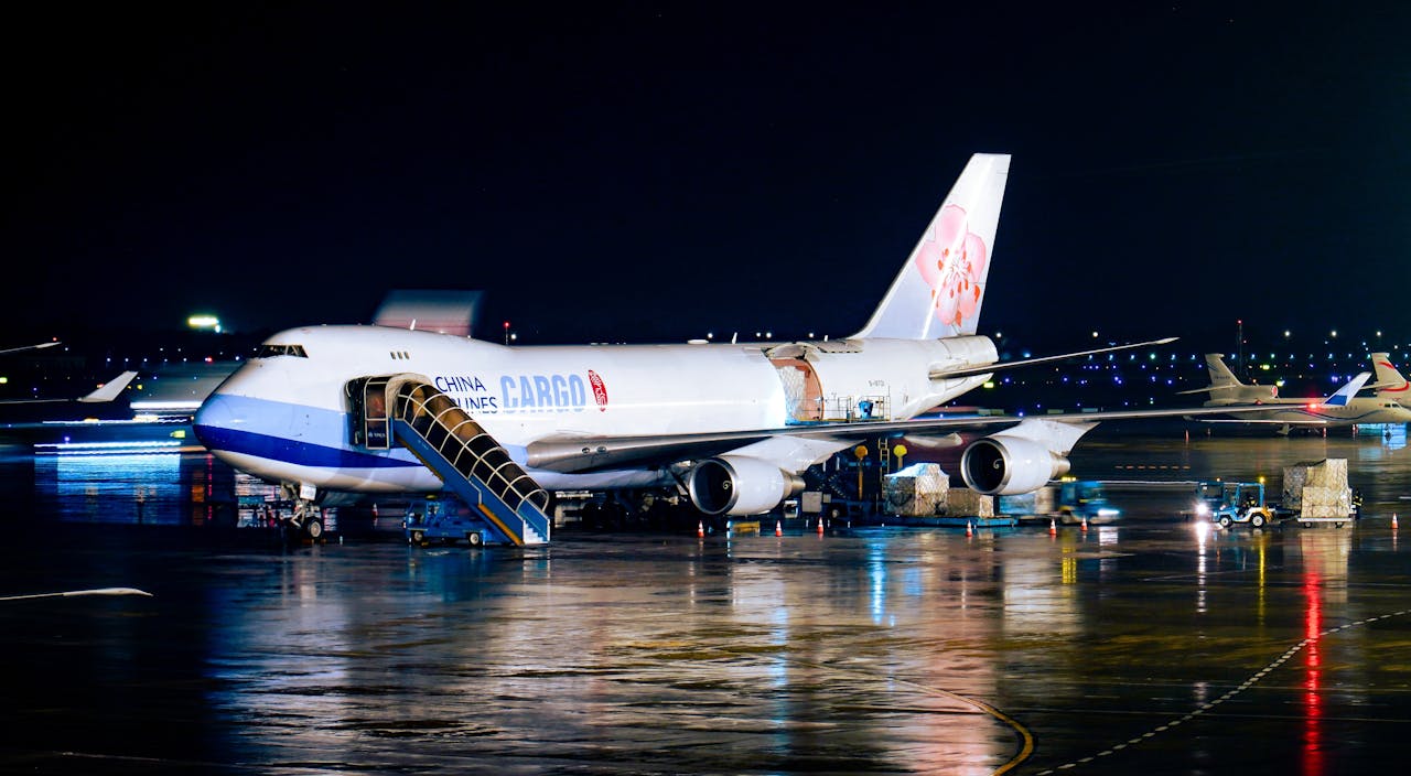 A China Airlines cargo plane being loaded at night with visible airport operations.